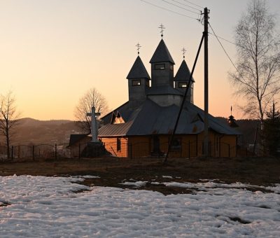 a building with a tower and a fence in the snow