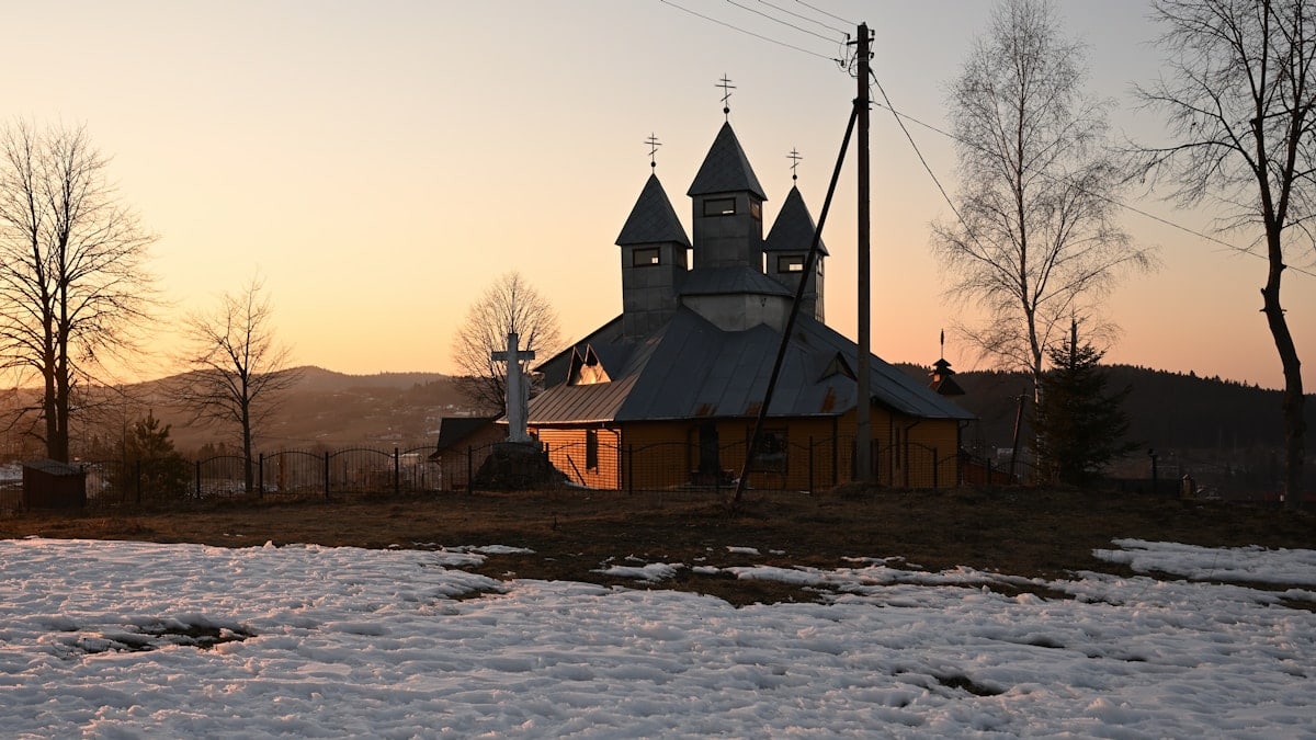 a building with a tower and a fence in the snow